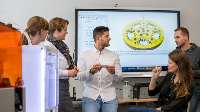 Junge Menschen diskutieren in einem Seminar vor einem Whiteboard