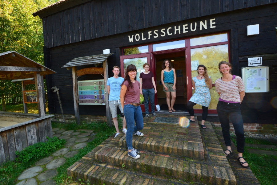 sechs junge Menschen stehen vor einer Scheune