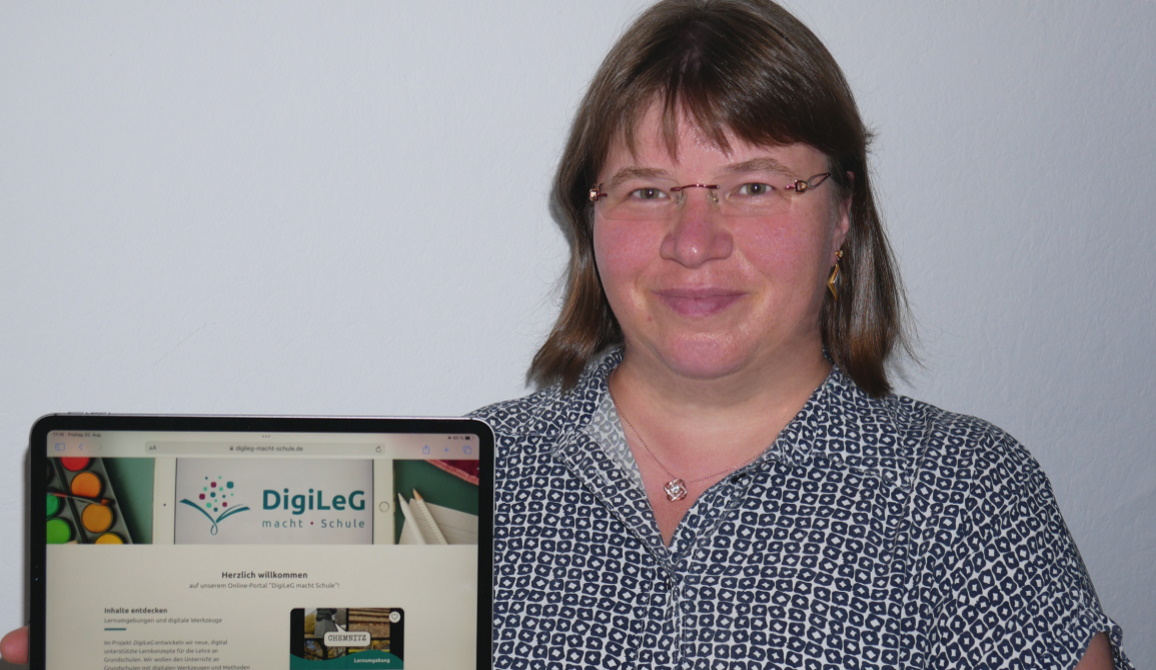 Prof. Dr. Leena Bröll hält ein Tablet in der Hand, auf dem das Online-Portal "digileg macht schule" zu sehen ist.