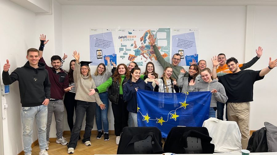 Eine Gruppe junger Menschen hält die Europaflagge.